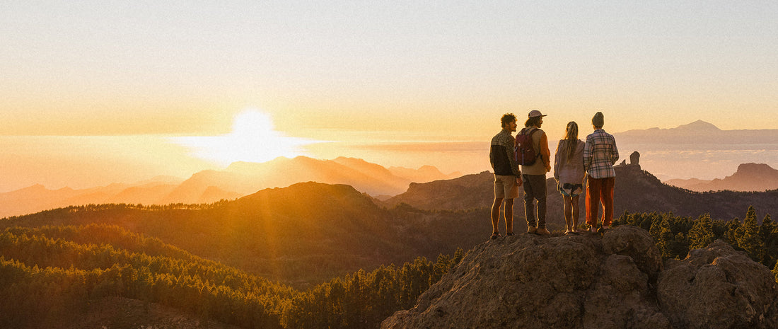 A group stood on a ridge, watching sunset