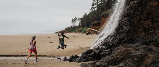 A man jumping over a stream on the beach